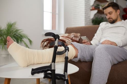 Man sitting on the couch with a broken leg